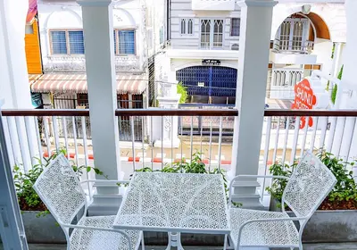 a porch with two white chairs and a white fence at Shunli Hotel - SHA Extra Plus in Phuket Town