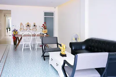 a living room with a couch and a table with chairs at Shunli Hotel - SHA Extra Plus in Phuket Town