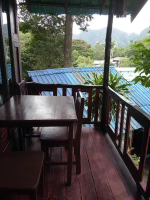 a porch with tables and chairs and a view at Phi Phi Green Hill Resort in Phi Phi Don