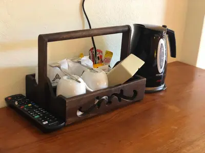 a black candle holder sitting on a table with a coffee mug at Phi Phi Villa Resort in Phi Phi Don