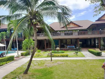 a palm tree in front of a house at Phi Phi Villa Resort in Phi Phi Don