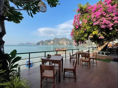 a restaurant with tables and chairs and a view of the ocean at Phi Phi Villa Resort in Phi Phi Don
