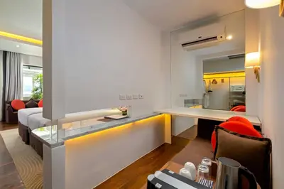 a room with a desk and a living room at The Boathouse Phuket-SHA Plus in Kata Beach