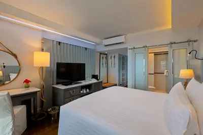 a hotel room with a bed and a television at The Boathouse Phuket-SHA Plus in Kata Beach