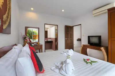 a hotel room with a bed with towels on it at Phuket Sea Resort SHA Extra Plus in Rawai Beach