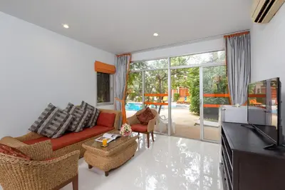 a living room with a red couch and chairs at Phuket Sea Resort SHA Extra Plus in Rawai Beach
