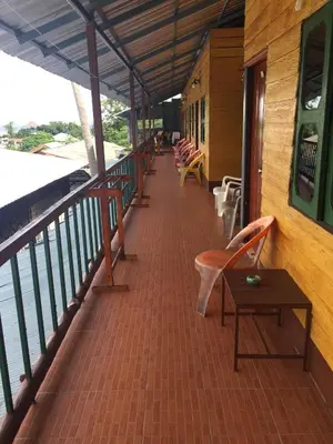 a balcony with chairs and tables on a boat at Scenery Guest House in Phi Phi Don