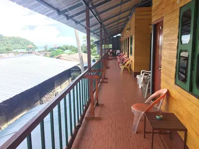 a balcony of a building with chairs and tables at Scenery Guest House in Phi Phi Don