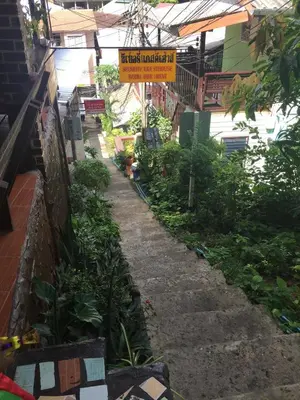 a garden path with a sign on the side of a building at Scenery Guest House in Phi Phi Don
