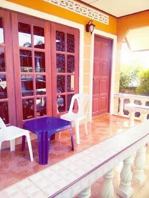 a porch with a purple bench on a house at The Endless Bangtao Residence VC 2 in Bang Tao Beach