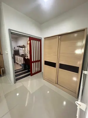 a living room with a large wooden closet and a kitchen at The Endless Bangtao Residence CAC 3 in Bang Tao Beach