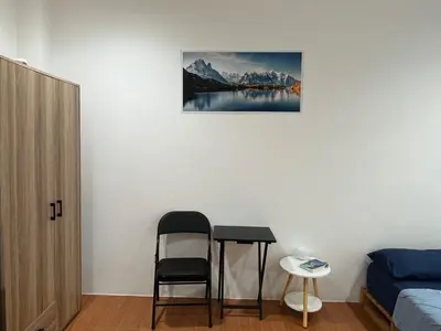 a room with a table and a chair and a picture at mom's home in Phuket Town