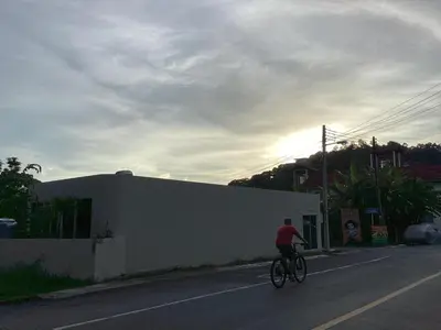 a person riding a bike down a street at mom's home in Phuket Town