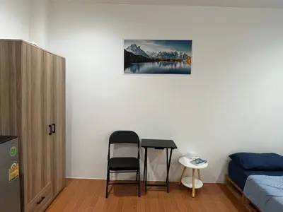 a bedroom with a bed and a table and a chair at mom's home in Phuket Town