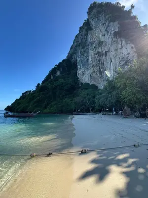 a sandy beach with a mountain in the background at Mama Beach Residence - Adults Only in Phi Phi Don