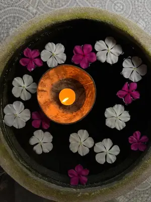 a bowl of flowers with a candle in the middle at Mama Beach Residence - Adults Only in Phi Phi Don