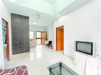 a living room with a tv on a wall at The Endless Bangtao Residence Wat 1 in Bang Tao Beach