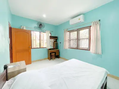 a bedroom with blue walls and a bed and windows at The Endless Bangtao Residence Wat 1 in Bang Tao Beach