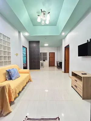 a living room with a couch and a flat screen tv at The Endless Bangtao Residence Wat 1 in Bang Tao Beach