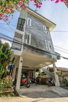 a building with motorcycles parked in front of it at The Endless Bangtao Apartment AC1234 in Bang Tao Beach