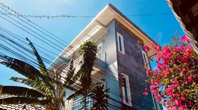 a tall building with pink flowers in front of it at The Endless Bangtao Apartment AC1234 in Bang Tao Beach