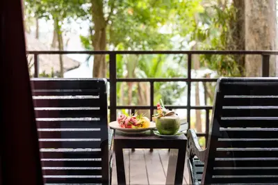 a plate of food on a table with two chairs at Baan Krating Phuket Resort Naiharn-SHA Plus in Nai Harn Beach