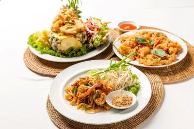 three plates of food on plates on a table at Baan Krating Phuket Resort Naiharn-SHA Plus in Nai Harn Beach