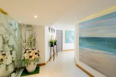 a room with flowers and paintings on the walls at Hotel De Karon in Karon Beach