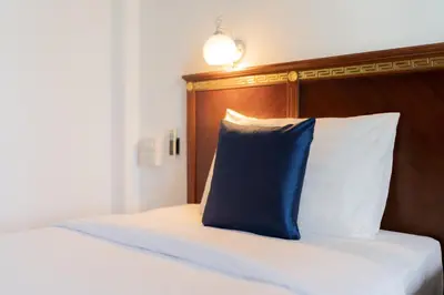 a blue pillow sitting on top of a bed at Hotel De Karon in Karon Beach