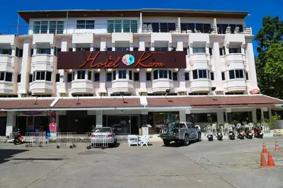 a hotel with a parking lot in front of it at Hotel De Karon in Karon Beach