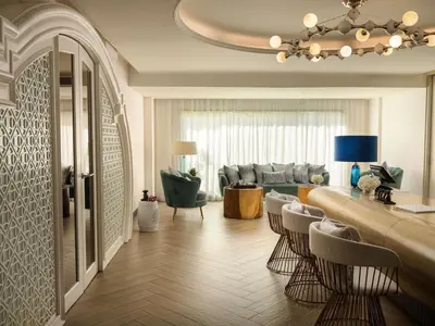 a living room with a bar with chairs and a couch at Avista Grande Phuket Karon - MGallery in Karon Beach