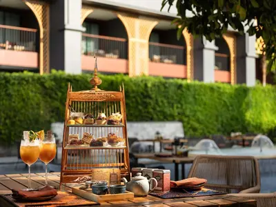 a table with a bird cage filled with food and drinks at Avista Grande Phuket Karon - MGallery in Karon Beach