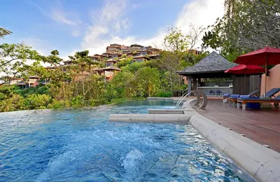 a swimming pool with a deck and a house at Sri Panwa Phuket Luxury Pool Villa Hotel in Panwa Beach