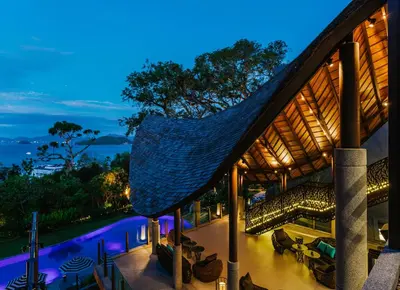 a house with a hammock on the roof at night at Sri Panwa Phuket Luxury Pool Villa Hotel in Panwa Beach