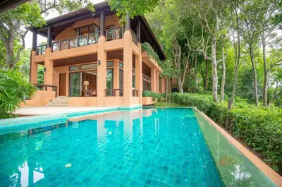 a house with a swimming pool in front of a house at Sri Panwa Phuket Luxury Pool Villa Hotel in Panwa Beach