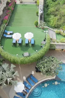 an overhead view of a pool with chairs and umbrellas at Palmyra Patong Resort Phuket - SHA Extra Plus in Patong Beach