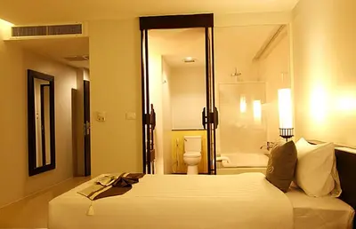 a hotel room with a bed and a bathroom at Palmyra Patong Resort Phuket - SHA Extra Plus in Patong Beach