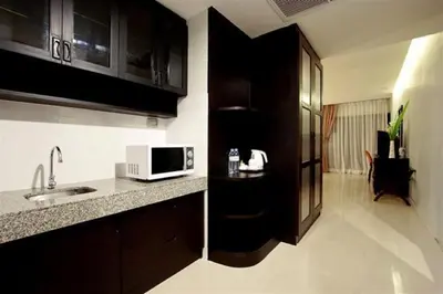 a kitchen with a sink and a microwave on a counter at Palmyra Patong Resort Phuket - SHA Extra Plus in Patong Beach