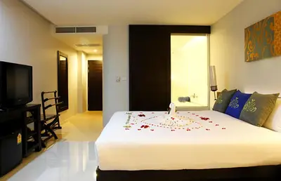 a bedroom with a bed with a candle on it at Palmyra Patong Resort Phuket - SHA Extra Plus in Patong Beach