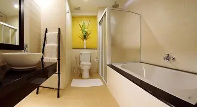 a bathroom with a tub and a toilet and a sink at Palmyra Patong Resort Phuket - SHA Extra Plus in Patong Beach