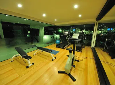 an exercise room with a treadmill and a piano at Palmyra Patong Resort Phuket - SHA Extra Plus in Patong Beach
