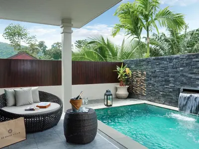 an outdoor patio with a swimming pool and a table and a chair at De Malee Pool Villas in Ao Nang Beach