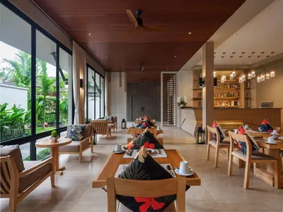 a restaurant with wooden tables and chairs and large windows at De Malee Pool Villas in Ao Nang Beach