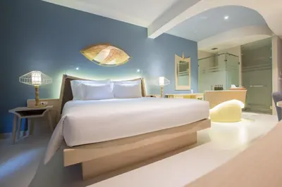 a bedroom with a large bed and a blue wall at Beyond Patong in Patong Beach