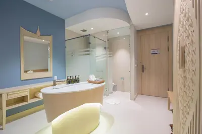 a bathroom with a large tub and a sink at Beyond Patong in Patong Beach