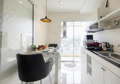 a kitchen with a black chair and a counter at Backpacker Street Airport Place in Nai Yang Beach