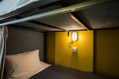 a bunk bed in a room with a yellow wall at Backpacker Street Airport Place in Nai Yang Beach