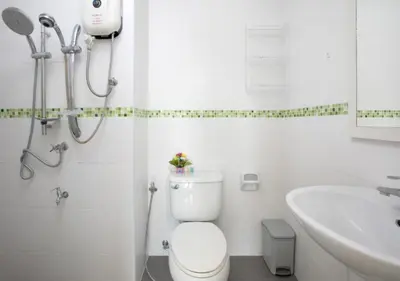 a white bathroom with a toilet and a sink at Backpacker Street Airport Place in Nai Yang Beach