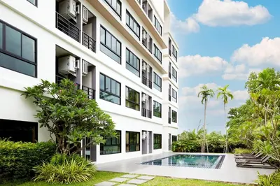 an exterior view of a building with a swimming pool at S4 Nai Yang Beach - Near Phuket Airport in Nai Yang Beach