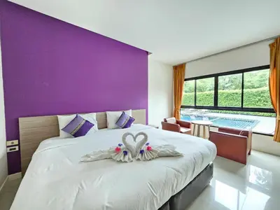 a bedroom with a large white bed with a purple wall at S4 Nai Yang Beach - Near Phuket Airport in Nai Yang Beach